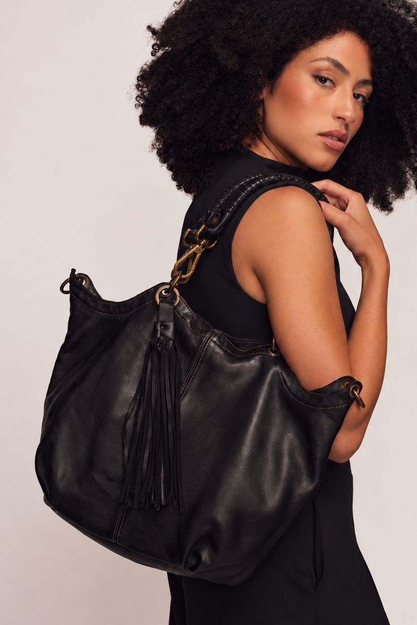 LUSHER Calla Lily Crossbody Hobo in Black Worn over the shoulder of the model showing the leather fringe